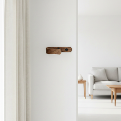 walnut curtain holdback on a white wall with a living room in the background